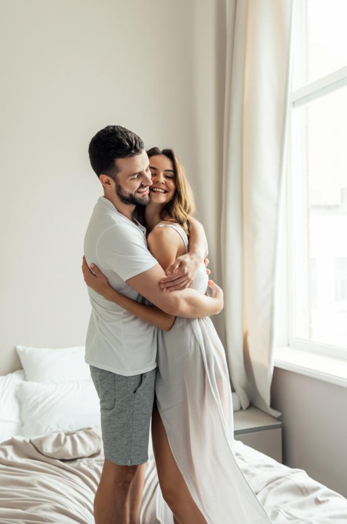 Happy couple embracing in bedroom